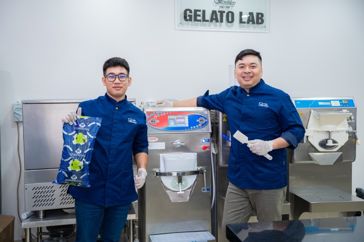 Charles Wembley team presenting gelato making process, staff gathered around equipment with colorful gelato on display, bright and cheerful training room, joyful and enthusiastic feeling